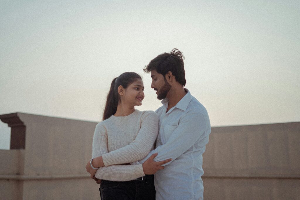 A couple embracing on a rooftop, looking into each other’s eyes, connected.