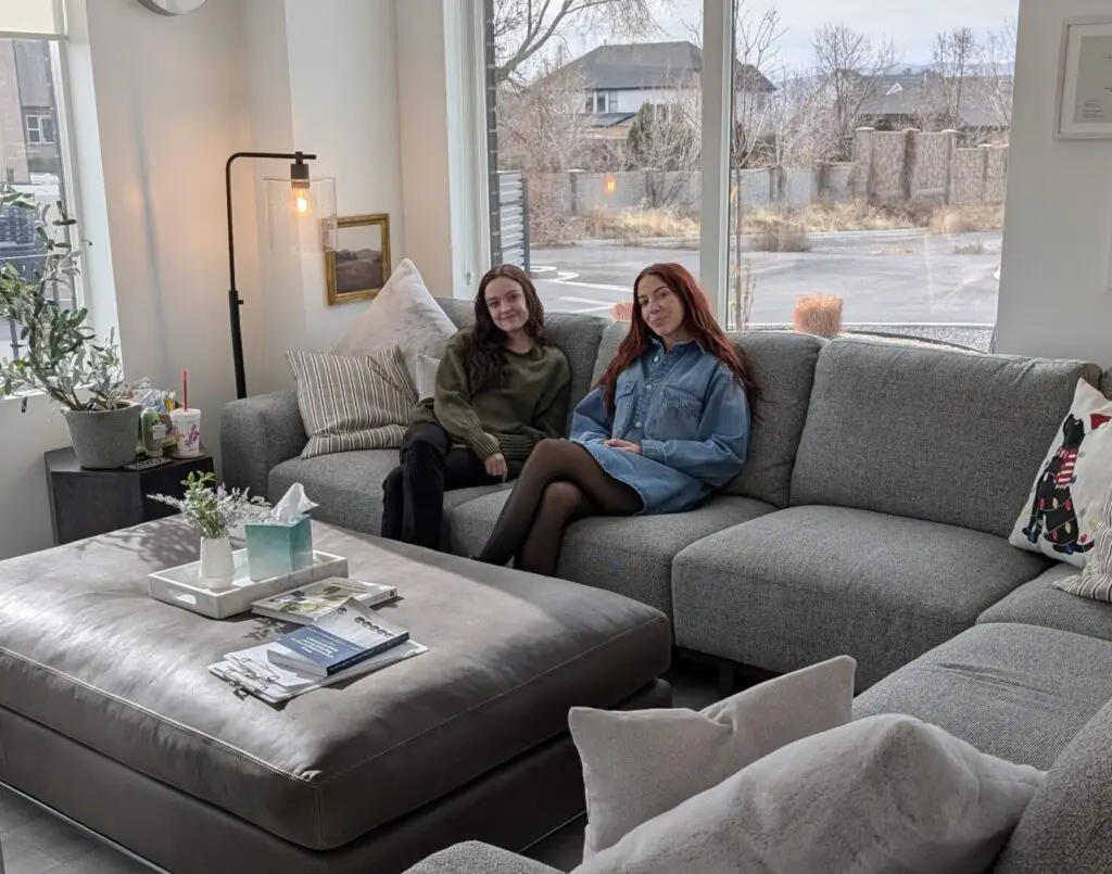 Clarissa Mace, MFT therapist, and Grace Samuels, UMFTI, sitting on a couch.