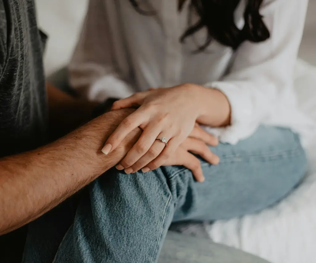 Close up shot of a couple holding hands.