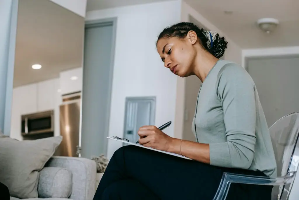 Woman couples therapist writing down notes on paper.