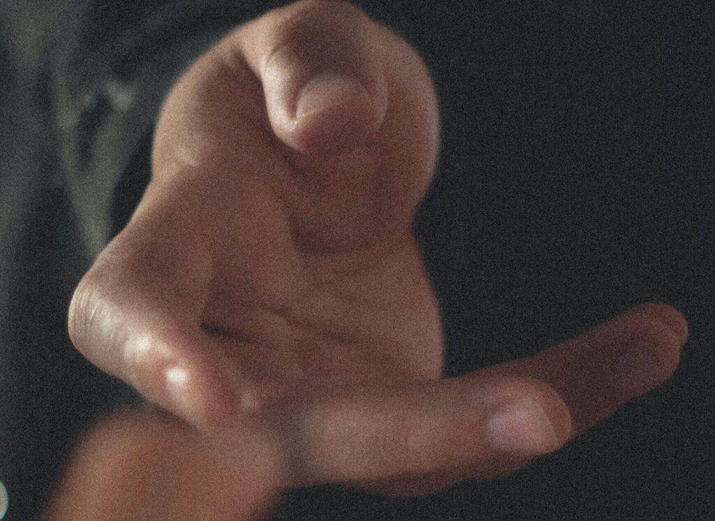 People yearning for each other while touching hands.