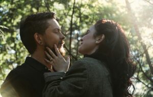 A couple gently touching foreheads in a forest, illustrating emotional intimacy and trust.