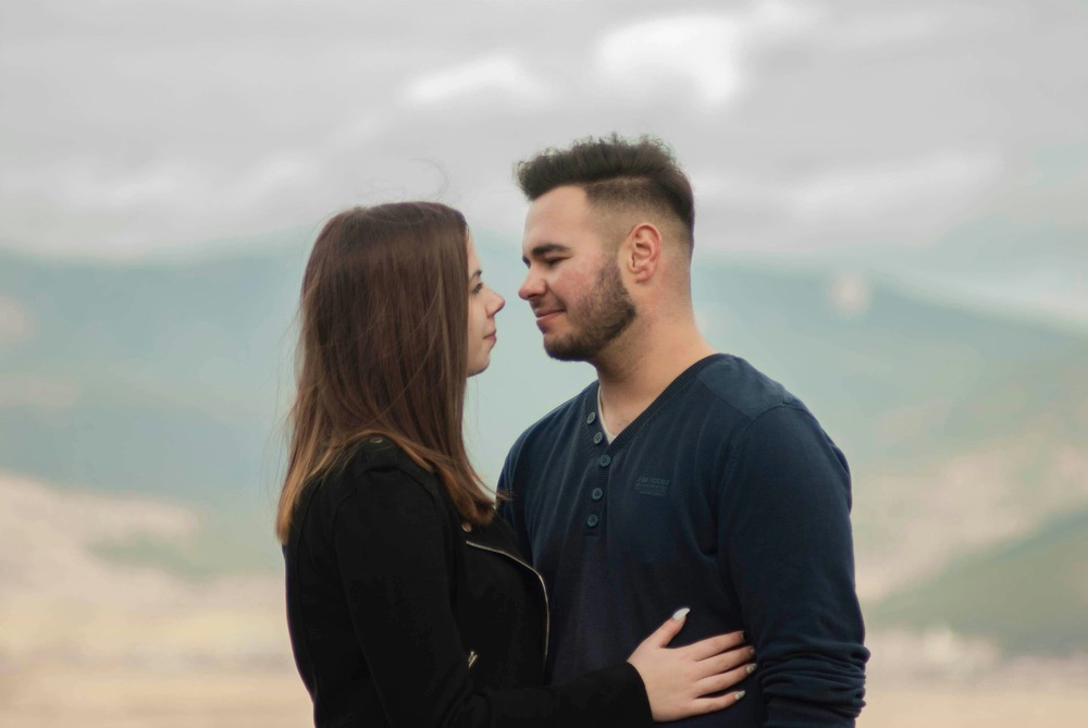 A couple standing closely face to face, expressing understanding and intimacy.
