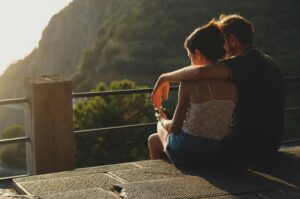 A couple sitting together overlooking a mountain view, suggesting peace and reflection after counseling.