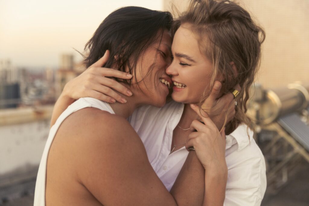 A couple smiling and gently embracing, showing warmth, trust, and emotional closeness.