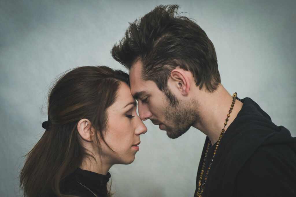A couple standing face to face, smiling with trust and mutual understanding.